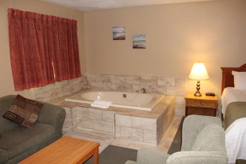 ein Wohnzimmer mit einer Badewanne in einem Hotelzimmer in der Unterkunft Colonial Resort-1000Islands in Gananoque