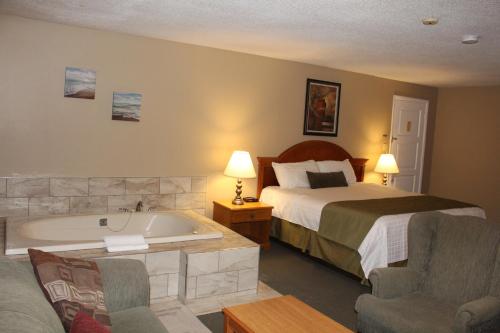 Habitación de hotel con cama y bañera en Colonial Resort-1000Islands, en Gananoque