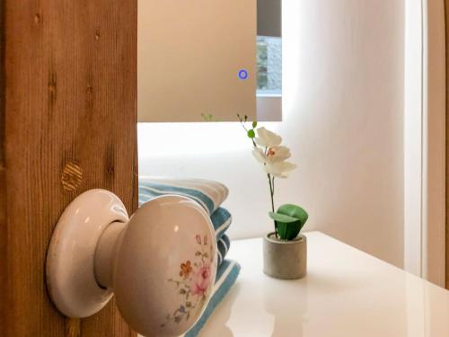 une tasse sur une porte avec un vase sur une table dans l'établissement THE OLD RECTORY SOUTHCOTT APARTMENT in Jacobstow 10 mins to Widemouth bay and Crackington Haven,15 mins Bude,20 mins tintagel, 27 mins Port Issac, à Jacobstow