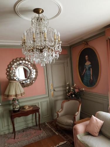 un salon avec un lustre et une chaise dans l'établissement Villa La Fontaine Sarlat La Caneda, à Sarlat-la-Canéda