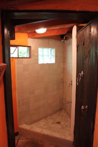 a bathroom with a shower with a tiled floor at Casa Hagan in Santa Cruz La Laguna