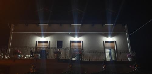 a white house with a balcony at night at Borgo12 in Pimonte