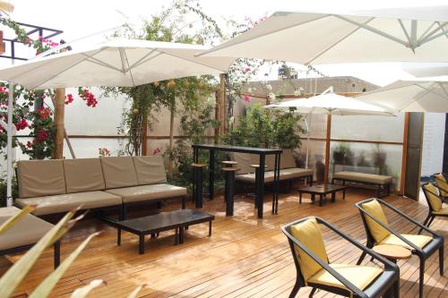 a patio with tables and chairs and umbrellas at Hotel Miramar in Huarmey
