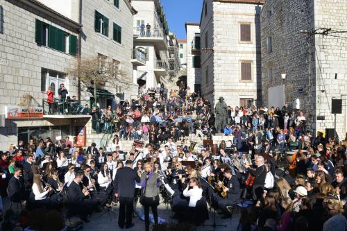 a large group of people playing music in the street at Ivica Apartments in Imotski