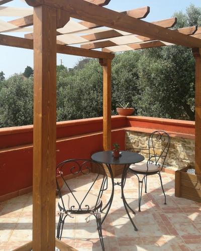 a table and chairs on a patio with a wooden pergola at Antica Residenza Voso in Laureana Cilento