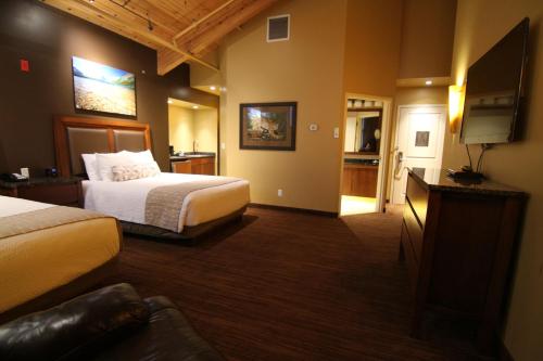 a hotel room with two beds and a flat screen tv at C'mon Inn Billings in Billings