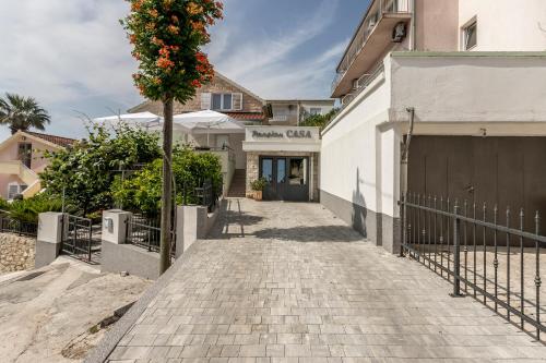a walkway with a tree in front of a building at Pansion Casa in Podstrana