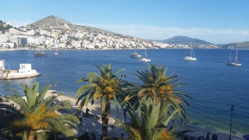 a large body of water with palm trees and boats at Hotel Ari 2 in Sarandë