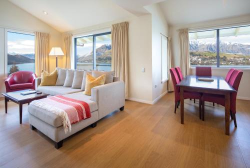 a living room with a couch and a table at Villa Del Lago in Queenstown