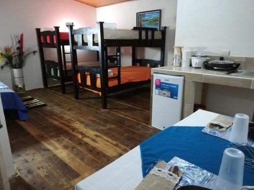 a living room with a kitchen and a table and chairs at Hotel Vistas del Cielo in Cartago