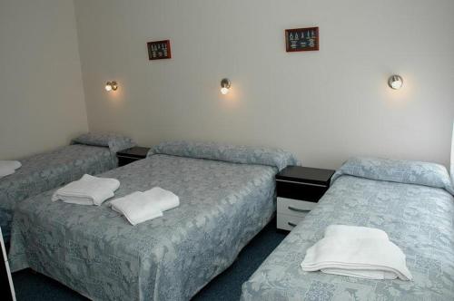 a room with two beds and towels on them at Hosteria Posada Drake in Puerto San Julián