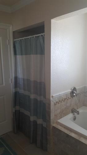 a bathroom with a shower curtain and a sink at Pierhouse Bed & Breakfast in Kill Devil Hills
