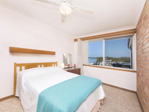 a bedroom with a bed and a window with a view at Fairholme 12 in Tuncurry