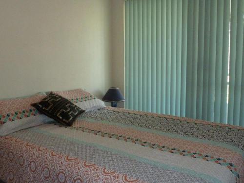 a bedroom with two beds with a lamp and a window at The Breakers 13 in Forster