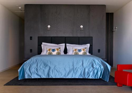 a bedroom with a blue bed with two pillows at Port Phillip Estate in Red Hill South