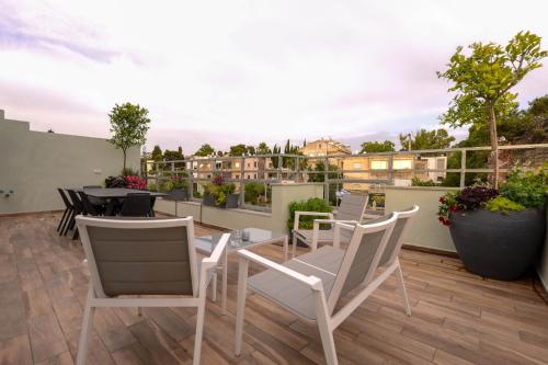 a patio with chairs and tables on a roof at Luxury Suites by Notaly Ariel in Haifa