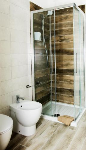 a bathroom with a glass shower and a toilet at LOCANDA VECCHIA FATTORIA in Monserrato