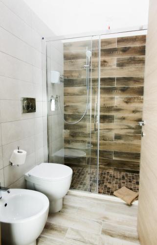 a bathroom with a toilet and a shower at LOCANDA VECCHIA FATTORIA in Monserrato