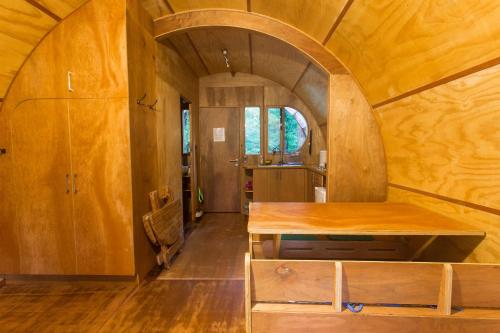 an arched room with a wooden table in a house at Cabaña Tinquilco in Collentañe