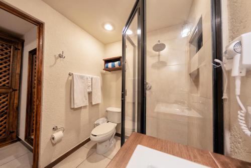 a bathroom with a toilet and a glass shower at Hotel Casa Yunenisa in Oaxaca City