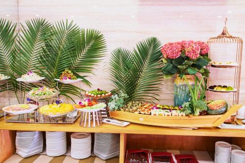 a table with a buffet of food and flowers at Boss Hotel in Nha Trang