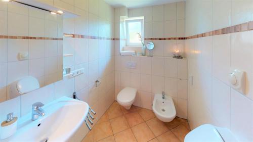 a bathroom with a toilet and a sink and a urinal at Feriendorf Südstrand Haus 09 in Pelzerhaken