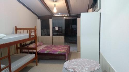a room with two bunk beds and a refrigerator at Espaço Elza Izabel in Piçarras
