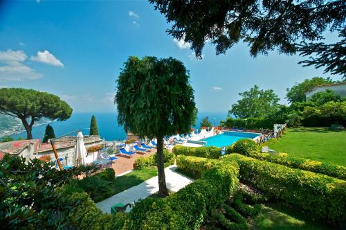 a view of a pool with chairs and a tree at Villa Casale Ravello Residence in Ravello