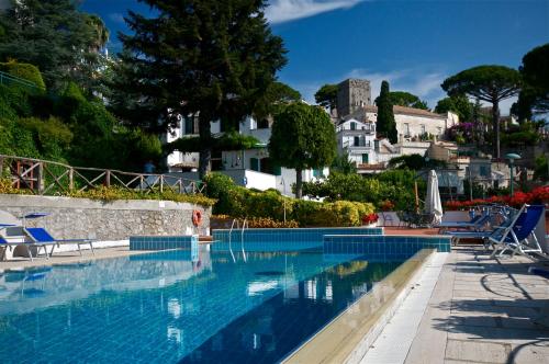 a swimming pool with chairs and houses in the background at Villa Casale Ravello Residence in Ravello