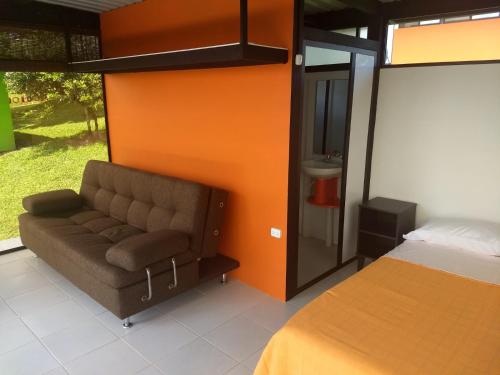 a bedroom with a couch next to a bed at Glamping - Calochorno in Alcalá