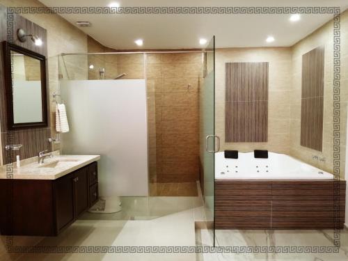 y baño con bañera, lavamanos y ducha. en Hotel Real Victoria, en Tepatitlán de Morelos