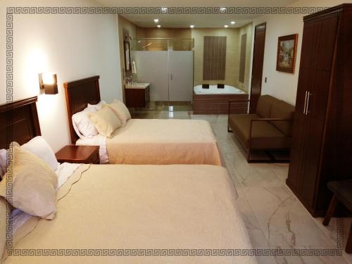 テパティトラン・デ・モレロスにあるHotel Real Victoriaのベッド2台とバスルームが備わるホテルルームです。