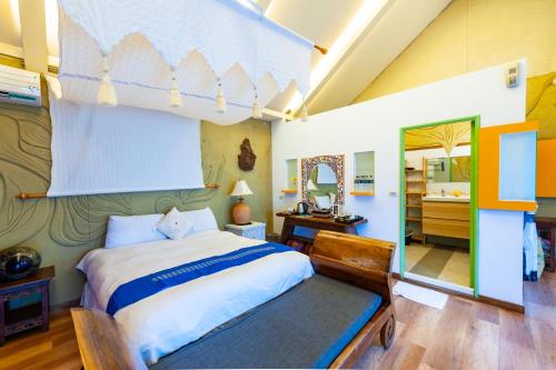a bedroom with a large bed and a bathroom at Pancala Vacation Inn in Nanwan