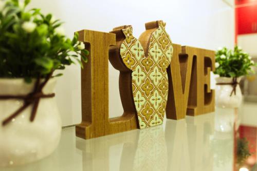 a wooden sign that says love on a table with plants at The Floral Home in Melaka