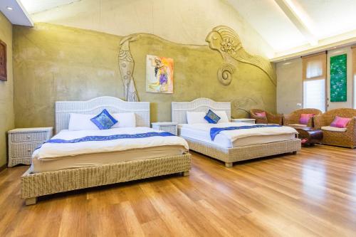 two beds in a room with a mural on the wall at Pancala Vacation Inn in Nanwan