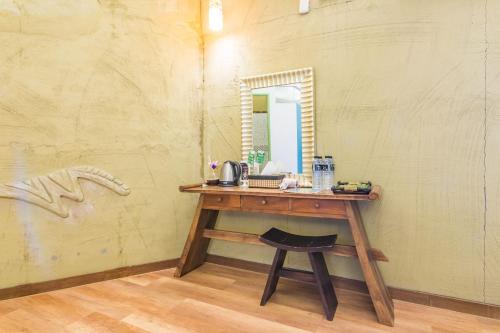 a dressing table with a mirror and a stool at Pancala Vacation Inn in Nanwan