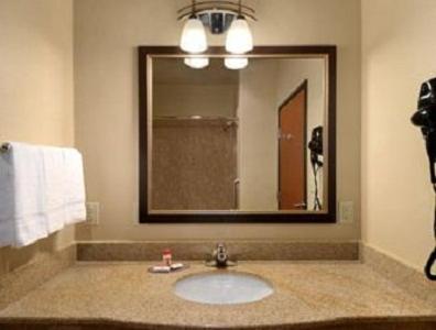 a bathroom with a sink and a large mirror at Super 8 by Wyndham Odessa TX in Odessa