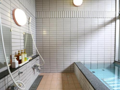 uma casa de banho com um chuveiro e uma banheira com um lavatório em Chino Sky View Hotel em Chino