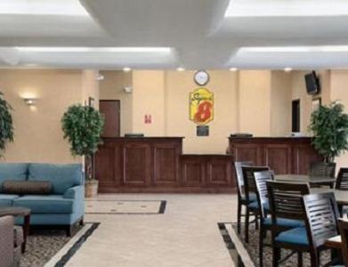 a waiting room with a blue couch and chairs at Super 8 by Wyndham Odessa TX in Odessa