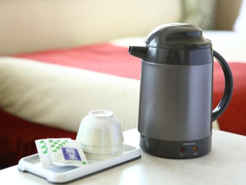 a tea kettle sitting on a table next to a plate at Chino Sky View Hotel in Chino