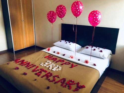 a bed with pink balloons and red flowers on it at Hotel Chua Gin in Cameron Highlands