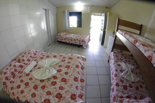 a room with two bunk beds and a room with two beds at Pousada Cataventos in Sirinhaém