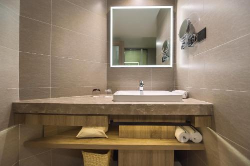a bathroom with a sink and a mirror at Hilton Garden Inn Zhuji East in Shaoxing