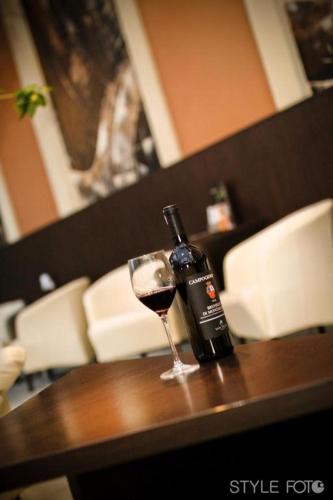 a bottle of wine and a glass on a table at Hotel Slovan in Lučenec