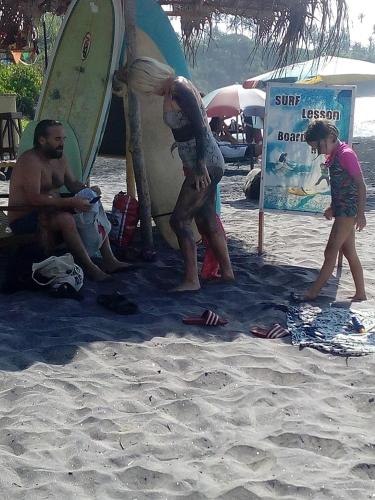 a group of people on a beach with a surfboard at Guillet Beach Home in Matara
