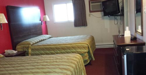 a hotel room with two beds and a television at Hallmark Motel in Cinnaminson