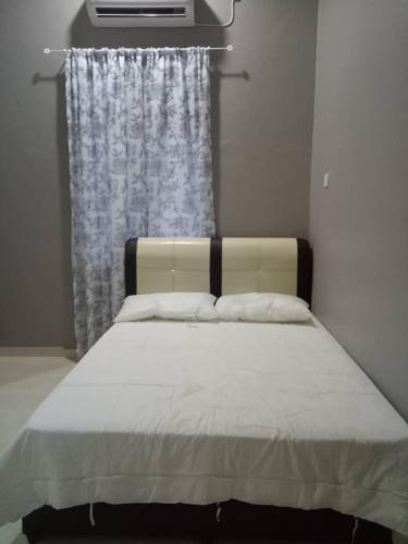 a bedroom with a bed with a curtain and a window at HOMESTAY SU in Marang