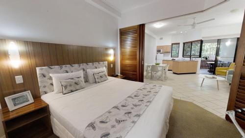 
a hotel room with two beds and a television at The Pavilions in Port Douglas
