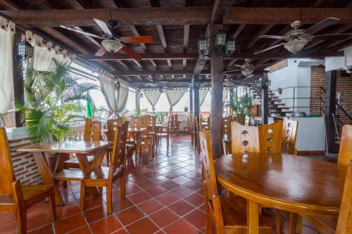 una sala da pranzo con tavoli e sedie in legno di Hotel Don Pedro De Heredia a Cartagena de Indias