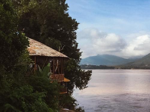 a hut on the side of a body of water at Ock Pop Tok Mekong Villa in Luang Prabang
